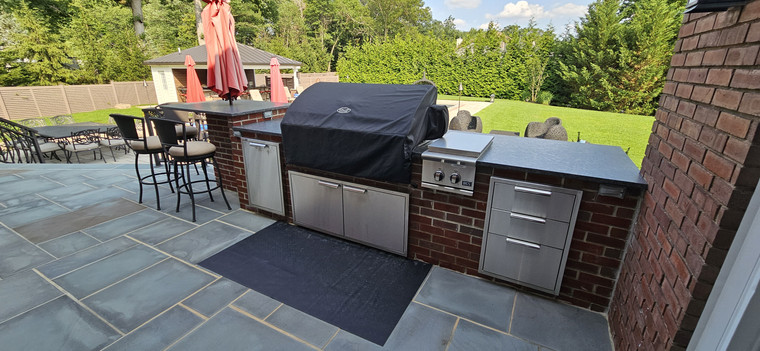 Bluestone-topped outdoor kitchen with built-in grill and stainless drawers