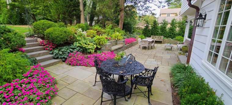Bluestone courtyard patio framed by lush perennial borders