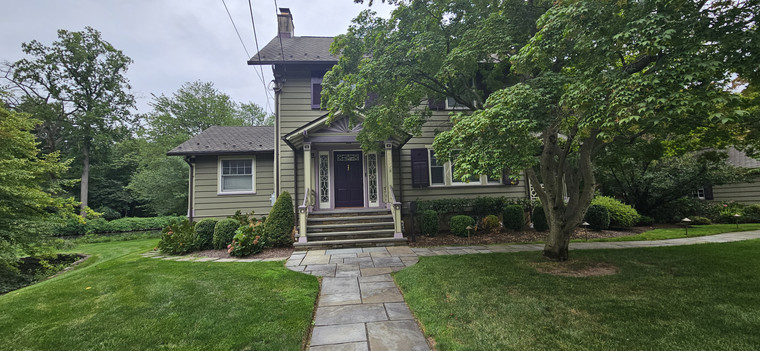 Bluestone walkway leading to a craftsman home with mature plantings