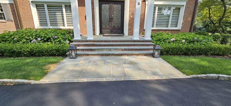 Bluestone front entry with brick risers and lantern-lit columned portico