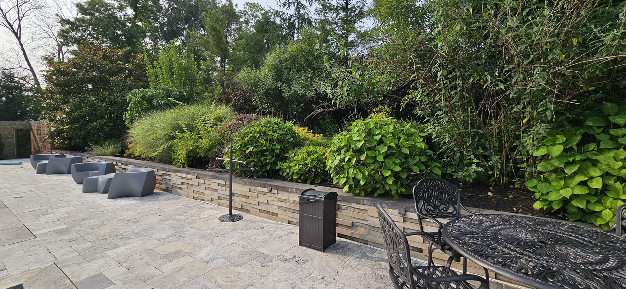Travertine patio with stacked-stone planter wall and lush garden border